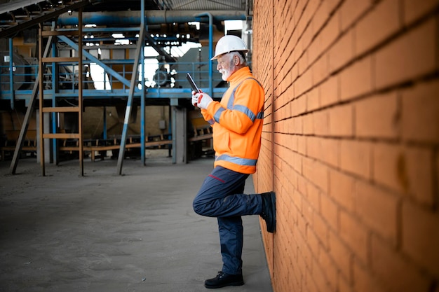 Industrial supervisor worker checking production results on tablet computer in factory.