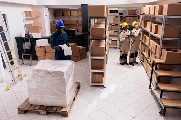 industrial warehouse coworkers doing freight inventory, managing big parcel delivery. storehouse employees making cargo transportation registration and scanning cardboard boxes barcodes