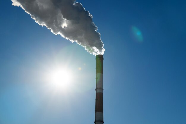 Industrial with thermal power plant and electric high voltage towers in sunlight