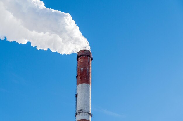 Industrial with thermal power plant and electric high voltage towers in sunlight