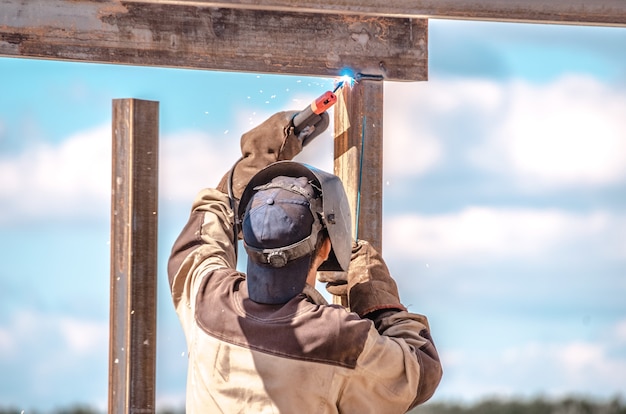 Industrial worker cutting metal outdoor