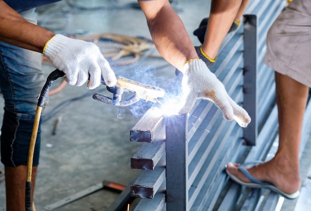 Industrial worker welding steel with sparks
