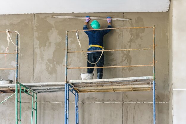 Industrial worker with plastering tools renovating a house