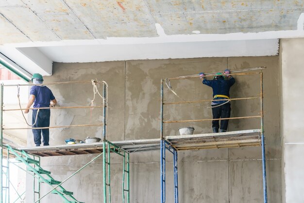 Industrial worker with plastering tools renovating a house. 