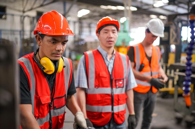 Industrieel ingenieurs in veiligheidshelmenWerk bij de fabriek voor de productie van de zware industrieIndustriële werknemer binnenshuis in de fabriek man aan het werk in een industriële fabriek