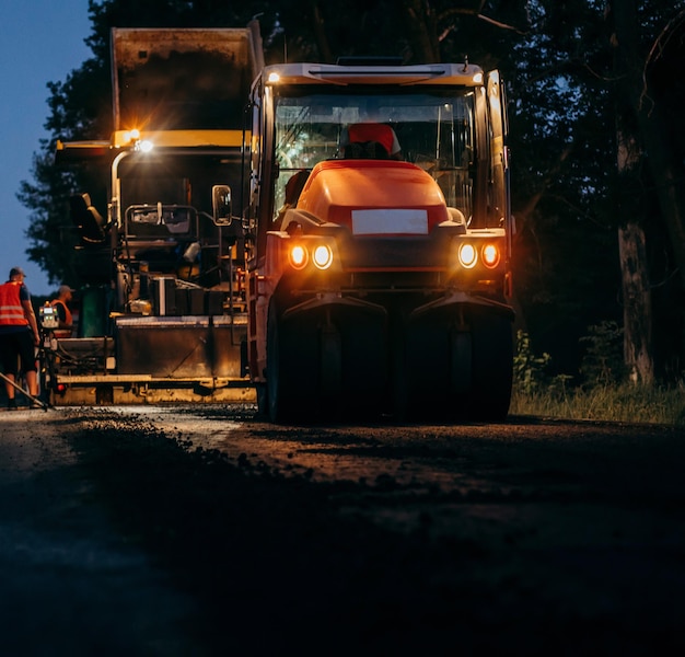 Industriële bestratingsvrachtwagen legt vers asfalt op bouwplaats Wegendienst repareert de hig