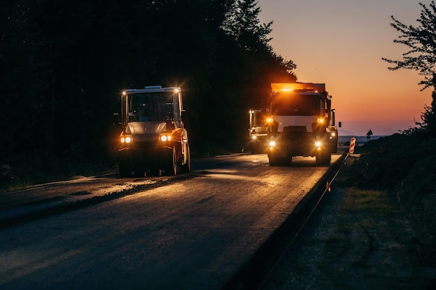Industriële bestratingsvrachtwagen legt vers asfalt op bouwplaats Wegendienst repareert de hig