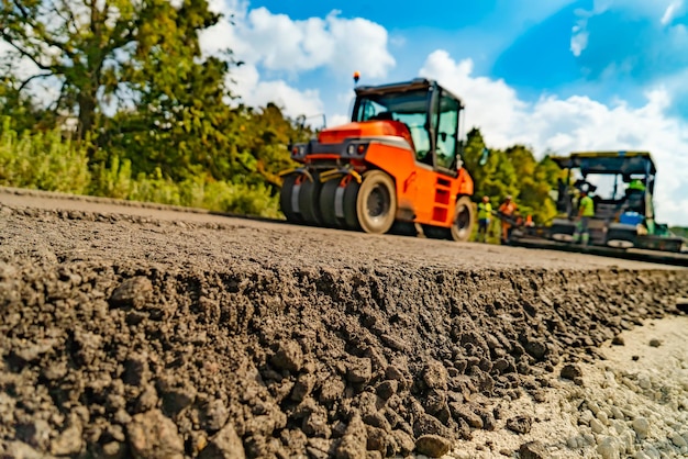 Industriële bestratingsvrachtwagen legt vers asfalt op bouwplaats zware machine-industrie werktuigbouwkunde