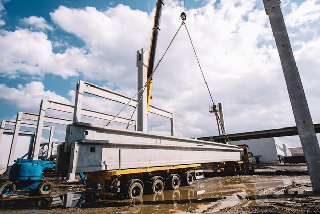 Industriële kraan die geprefabriceerde cementpijlers van lading lost