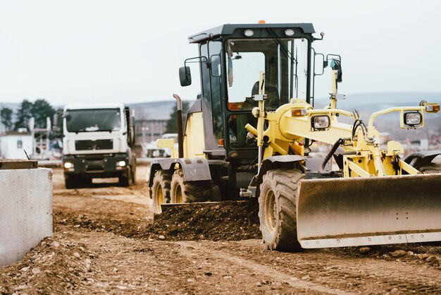 Industriële motorgrader die werkt op de bouwplaats van de snelweg