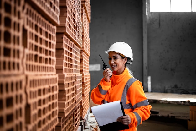 Industriële productie van bakstenen voor de bouwnijverheid en arbeiders die de inventaris in de fabriek controleren;