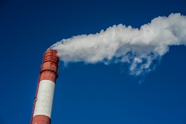 Industriële rook van schoorsteen op blauwe hemel