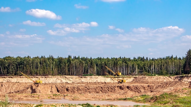 Industriële steengroeve Zandwinning Graafmachines tegen de achtergrond van de natuur