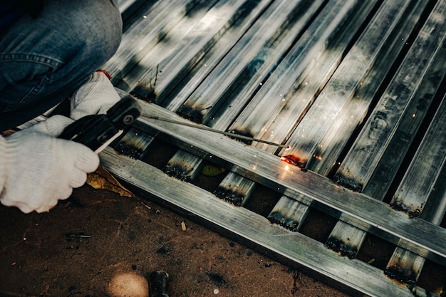 Industriële werknemer met witte handschoen en lasijzer op het werk buiten Closeup handgereedschap voor het lassen van staal Concept industrieel met behulp van lasmachine voor de bouw