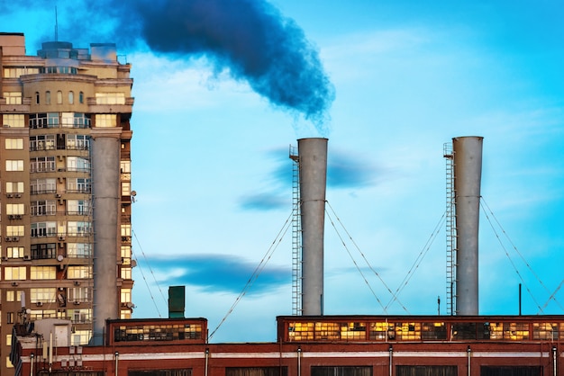 Industriële zwarte giftige rook van kolencentrale op blauwe hemel