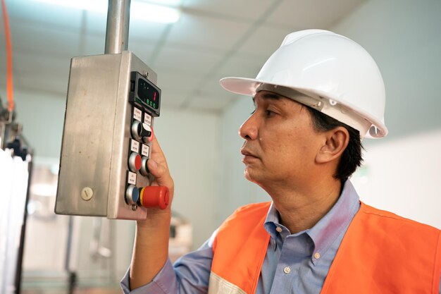 Industry worker entering data in cnc machine at factory