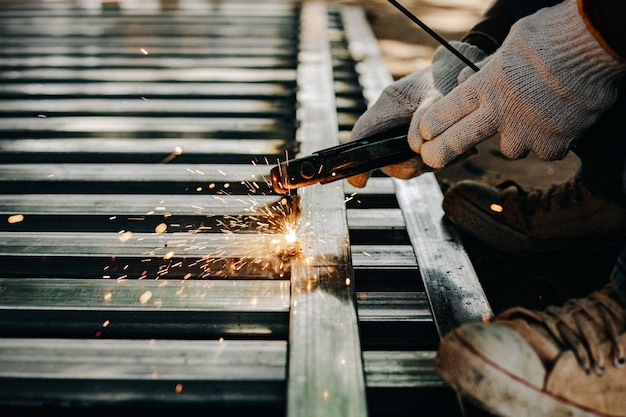 Photo industry worker wearing white glove and welding iron at work outdoor closeup hand tool for welding steel concept industrial using welding machine for construction