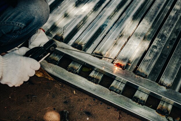 Industry worker wearing white glove and welding iron at work outdoor Closeup hand tool for welding steel Concept industrial using welding machine for construction