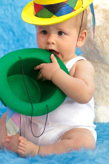 An infant on a blue background with toys