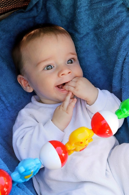 An infant sits in a stroller and happily watches