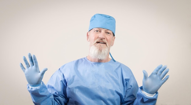 Infectious disease doctor in blue protective shows hands in protective rubber gloves