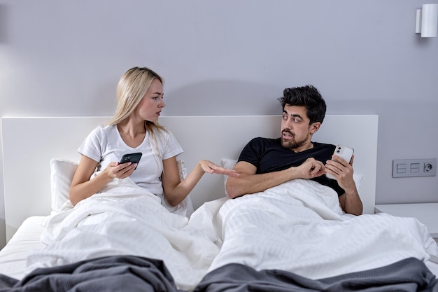 Premium Photo Infidelity. cheating caucasian husband texting on phone with lover ignoring unhappy jealous wife lying in bed at home picture photo