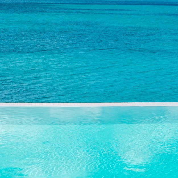 Пейзажный бассейн в роскошном отеле на фоне тропического курорта на берегу океана