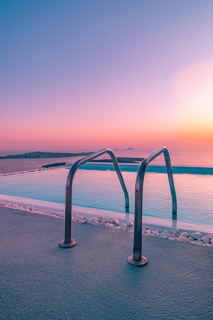 Infinity pool on the rooftop at sunset in Santorini Island, Greece. Beautiful poolside sunset sky