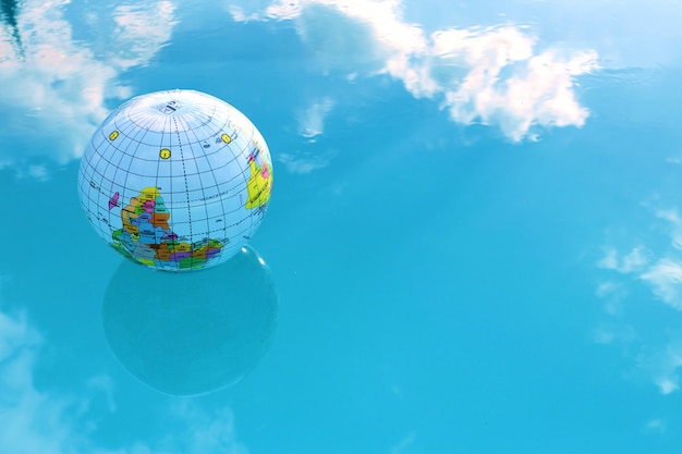 Photo inflatable ball in globe form in blue water