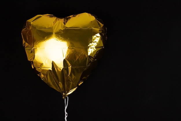 Inflatable balloon in the shape of a heart of golden color