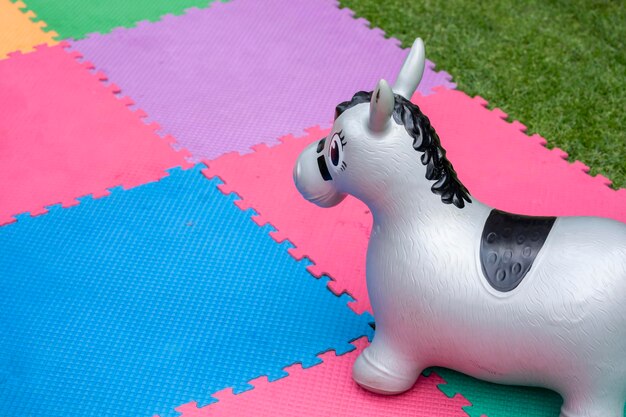 Inflatable horse on a colorful mat in a children's party garden