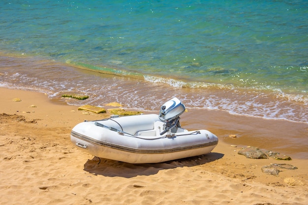 Надувная моторная лодка на песчаном пляже Средиземного моря