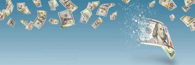Инфляция, гиперинфляция, долларовая стагфляция. Стодолларовая банкнота распыляется на синем фоне. Законопроект отбрасывает тень. Снижение покупательной способности, инфляция. Деньги падают с неба