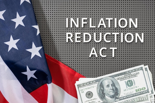 Inflation reduction Act law concept Fat lay of text american flag and dollar banknotes