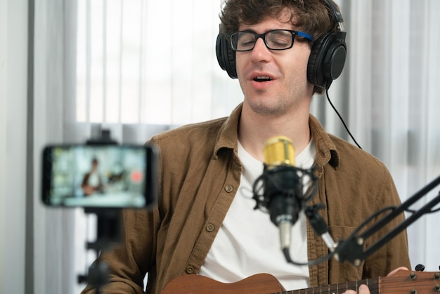 Influencer singing with playing guitar to fanclub on social media phone Gusher