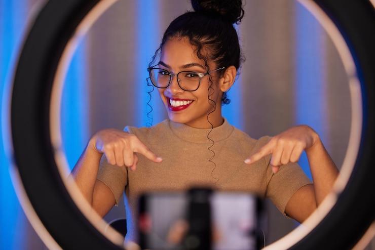 Foto influencer vrouw ringlicht en portret met glimlach wijzend en schoonheid op livestream uitzending of webvideo meisjesrecensie of online ondernemer met geluksmake-up of praten op sociale media