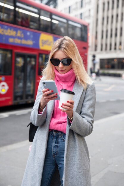 Photo influencer walking and using her smartphone