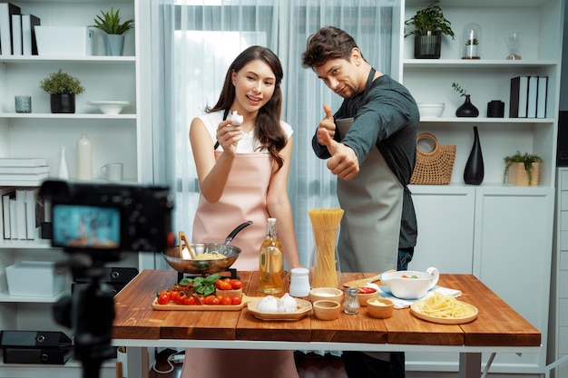 Influencers on cooking show presenting ingredient of spaghetti dish Postulate