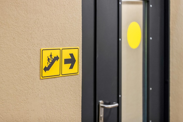 Informatiebord dat de locatie van de gele trap aangeeft tegen de achtergrond van een ijzeren deur