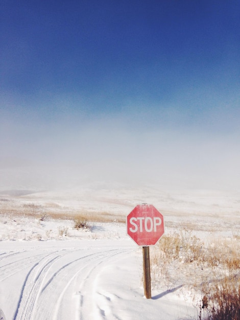 Informatiebord over een met sneeuw bedekt landschap tegen een heldere lucht