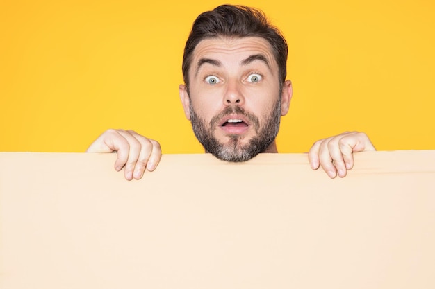 Information concept surprised man with blank placard demonstrating copy space for text or design