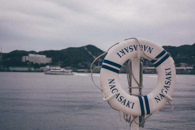 Photo information sign by sea against sky