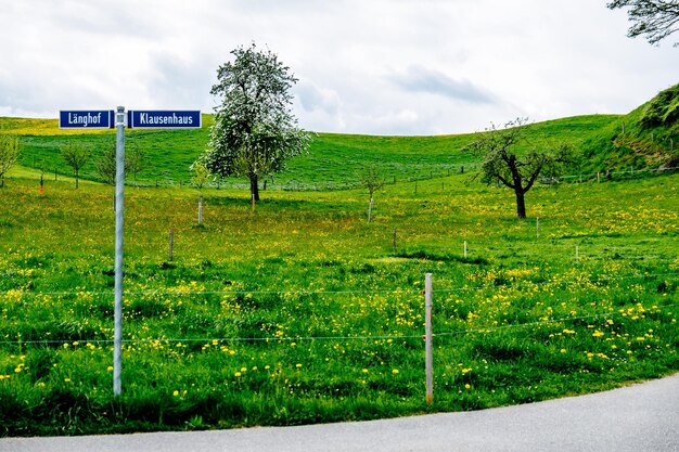 Information sign on field against sky