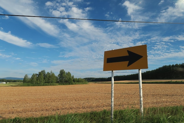 Foto segno informativo sul campo contro il cielo