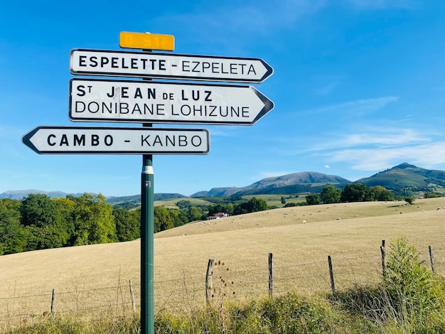 Foto segno informativo sul campo lungo la strada contro il cielo