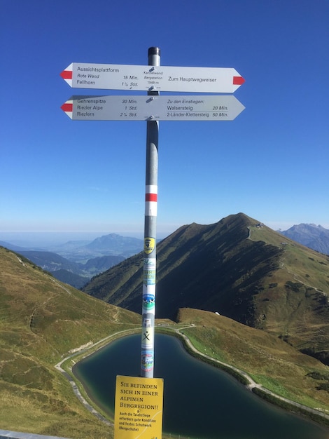 Information sign on mountain road against sky