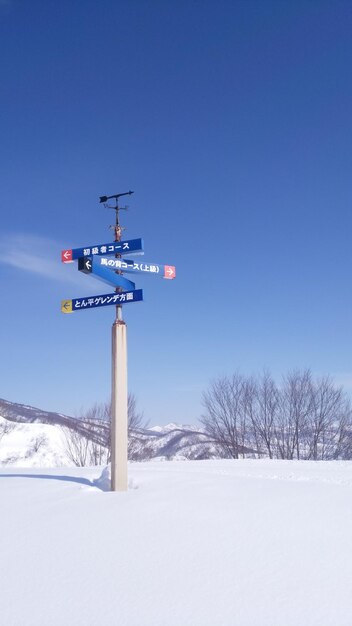 Photo information sign on snow covered field against sky