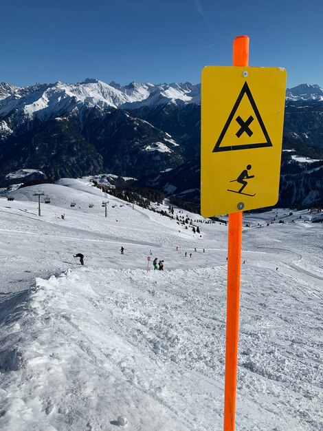 Foto segno informativo su una montagna coperta di neve contro il cielo