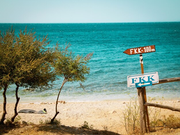 Foto segni informativi sulla spiaggia contro il cielo