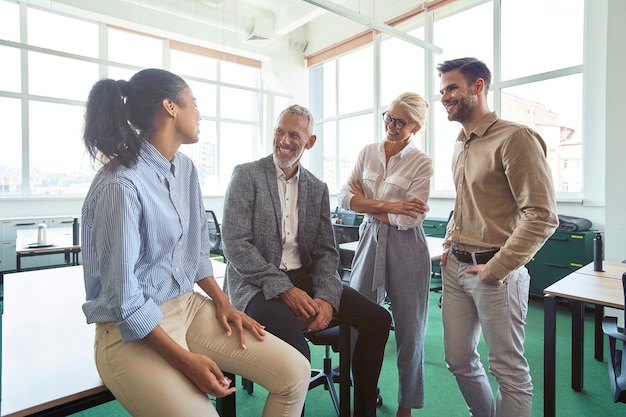 Informeel gesprek succesvol multiraciaal zakelijk team dat in het moderne kantoor praat